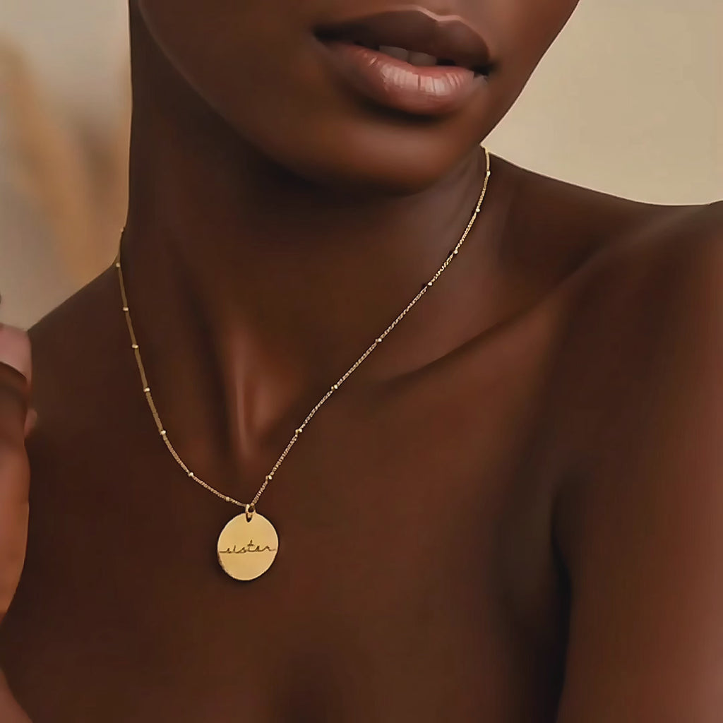 Video showcasing a 19mm round disc necklace available in yellow gold-filled, rose gold-filled, or sterling silver, featuring a custom engraved name, monogram, or short saying; minimalist personalized pendant on a delicate beaded chain, perfect for everyday wear or gifting.