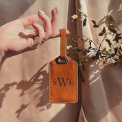 Personalized leather luggage tag video showing a cognac-brown tag with laser-engraved monogram initials (“SWE”), stitched edges, and a secure strap with metal hardware. Short clip highlights the durable full-grain leather, adjustable attachment, and smooth finish—ideal personalized luggage tag, monogram luggage tag, or engraved travel gift for suitcases, carry-ons, and backpacks; perfect for travelers, weddings, honeymoons, grads, and business trips.