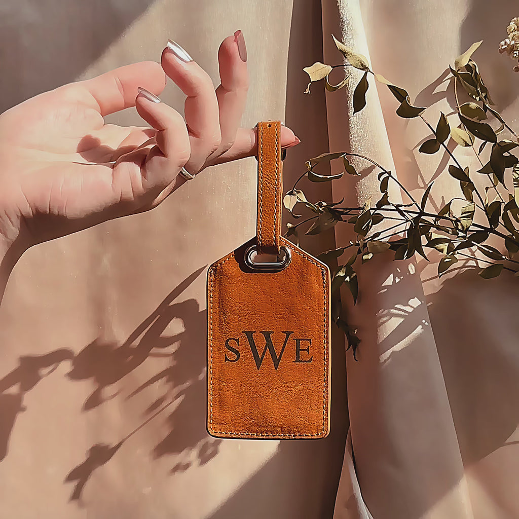 Personalized leather luggage tag video showing a cognac-brown tag with laser-engraved monogram initials (“SWE”), stitched edges, and a secure strap with metal hardware. Short clip highlights the durable full-grain leather, adjustable attachment, and smooth finish—ideal personalized luggage tag, monogram luggage tag, or engraved travel gift for suitcases, carry-ons, and backpacks; perfect for travelers, weddings, honeymoons, grads, and business trips.