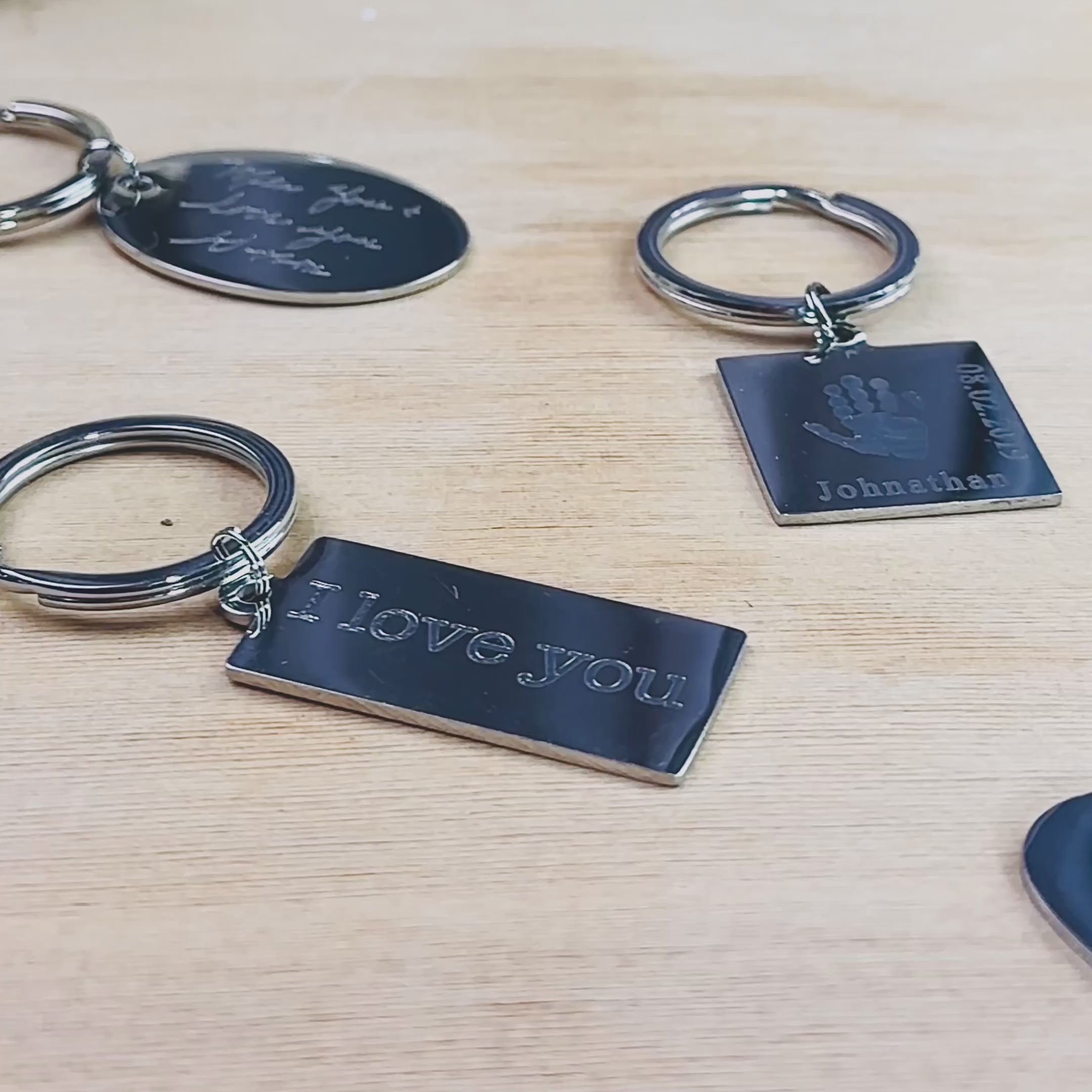 A video shows  a large assortment of personalized stainless steel keychains with different engravings on each of them. Available shapes are heart, large rectangle, small rectangle, circle, square, and oval. Engrave handwriting, drawings, or images of footprints, handprints or fingerprints! Create a personalized unique Christmas or Birthday celebration gift for a loved one, new mom, new driver, or an extra special birthday! Customize to your heart's content!