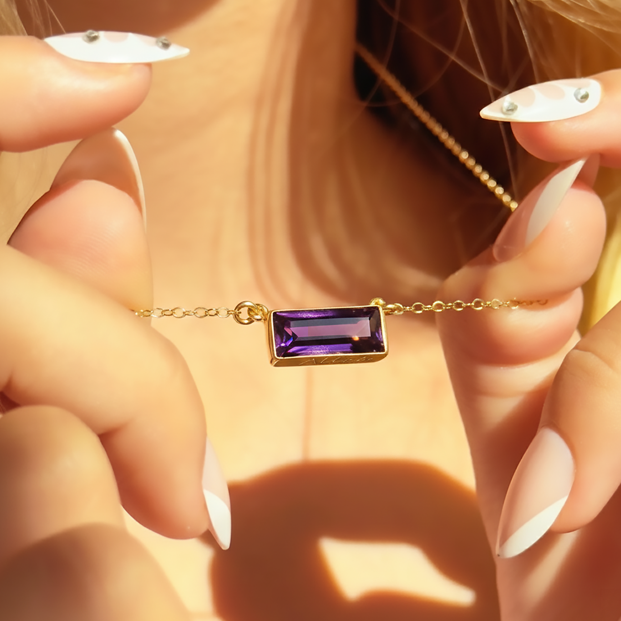 Gold birthstone bar necklace with rectangular purple amethyst stone showing hidden engraved message on the back