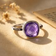Sterling silver cushion amethyst ring with faceted purple gemstone and white topaz pave accents.