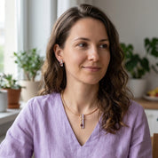 Woman wearing custom color geometric pendant necklace and matching earrings with lavender top

