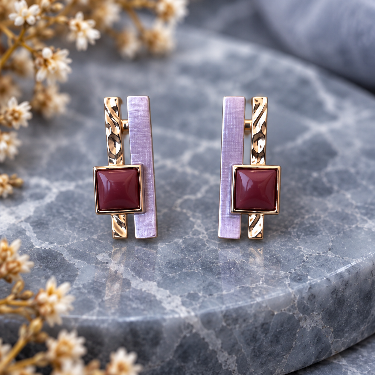 Lavender Burgundy geometric earrings with layered bars displayed on gray stone