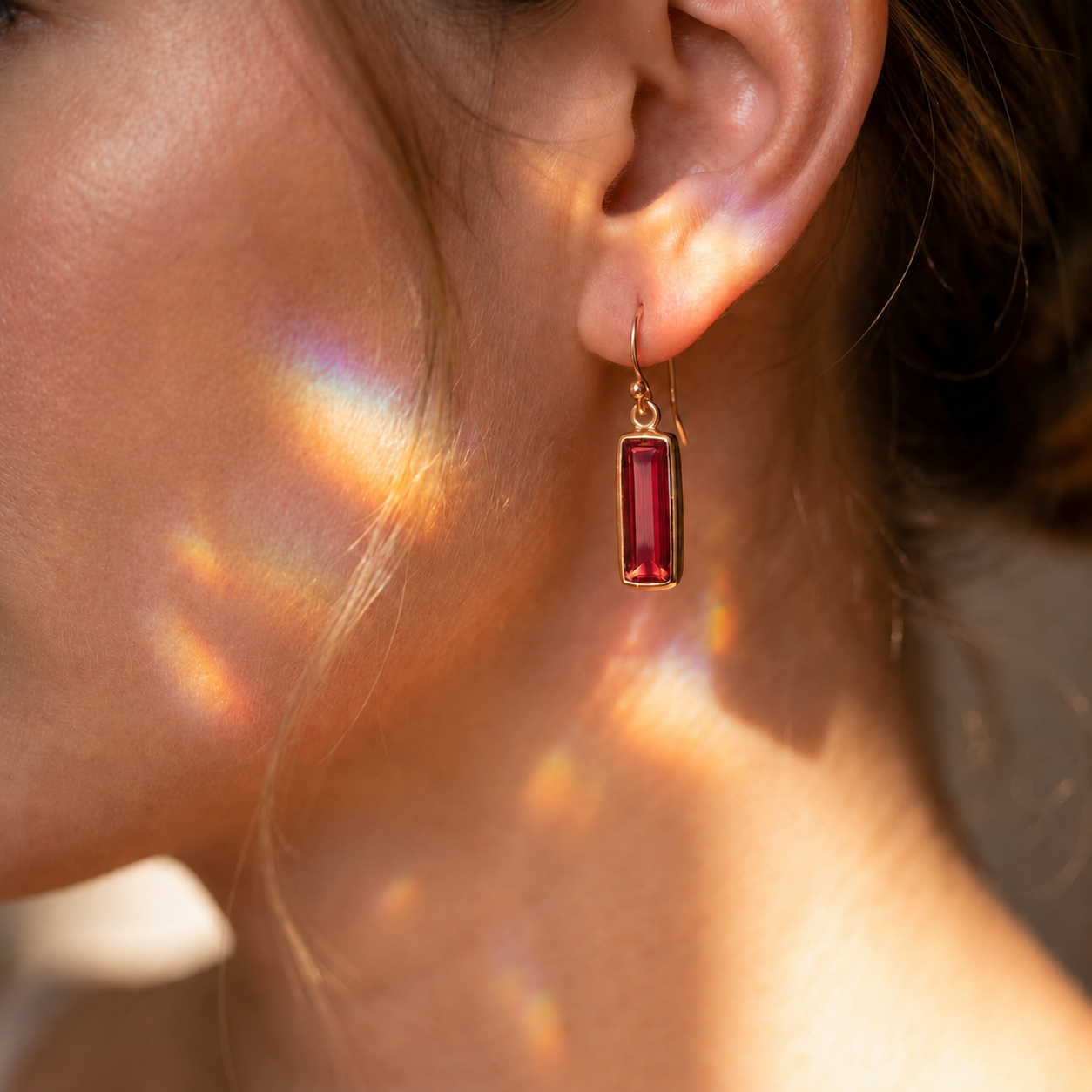Woman wearing a Ruby Quartz bar earring in warm natural sunlight