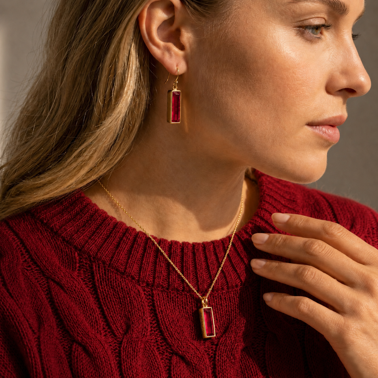 Woman wearing Ruby Quartz bar earrings with a matching necklace and red sweater