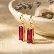 Ruby Quartz baguette drop earrings in yellow gold vermeil on a cream jewelry dish