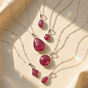 Ruby quartz necklaces in different pendant styles and metal finishes displayed with soft sunlight.