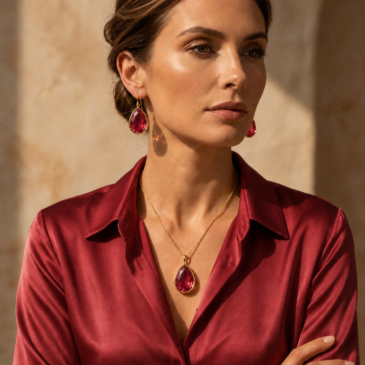 Model wearing ruby quartz teardrop earrings and matching ruby necklace with a ruby red blouse.