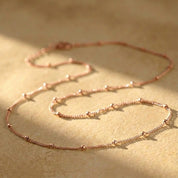 Rose Gold choker necklace styled on a model to demonstrate how the minimalist chain layers beautifully with other necklaces while remaining elegant on its own