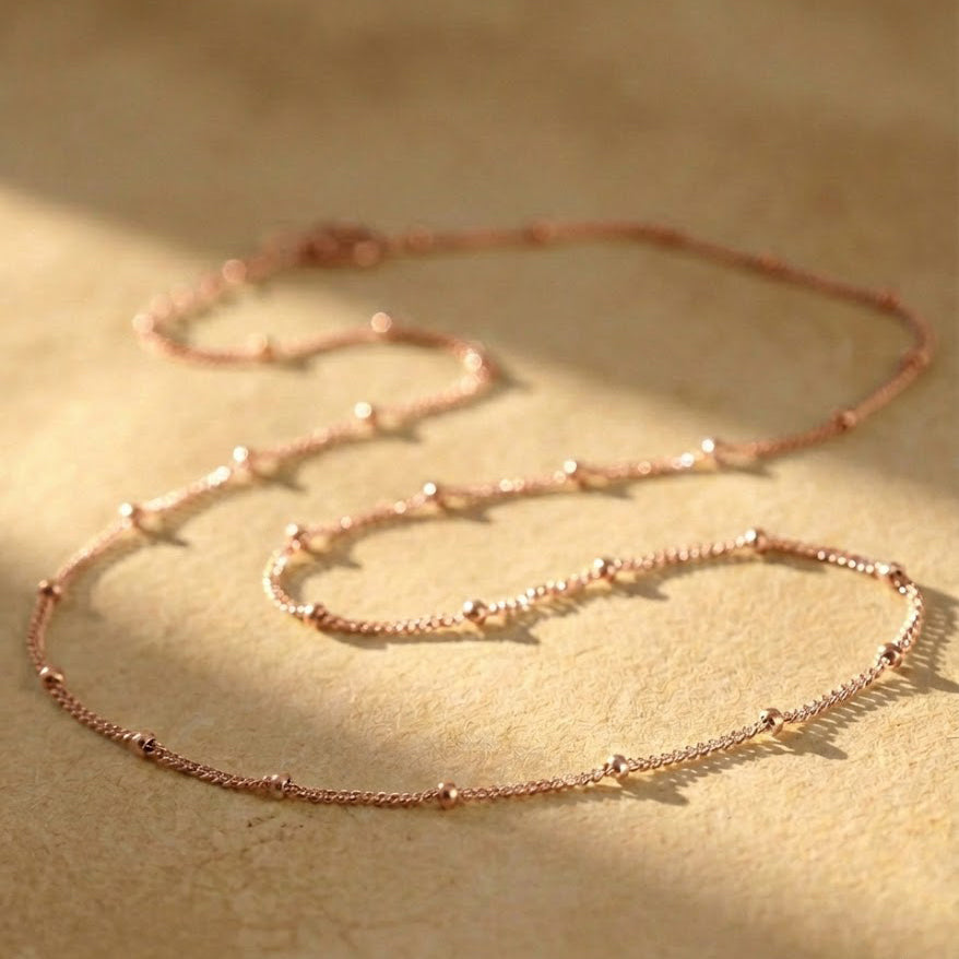 Rose Gold choker necklace styled on a model to demonstrate how the minimalist chain layers beautifully with other necklaces while remaining elegant on its own