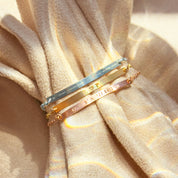 Stacked morse code skinny bar necklaces displayed on soft neutral fabric, featuring engraved hidden messages in sterling silver, gold filled, and rose gold finishes. Personalized morse code jewelry with dots and dashes translating meaningful words, initials, or coordinates. Minimalist bar necklace design perfect as a secret message necklace, sentimental gift for her, sister, mother, or bridesmaid, ideal for anniversaries, Valentine’s Day, or everyday wear.