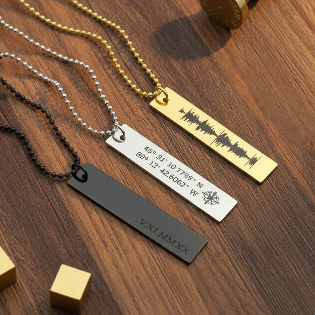 Several personalized stainless steel dog tag necklaces arranged on rustic wood background, each engraved with different designs (coordinates, name, special date). Shows variety of options for customizing dog tag gifts for him, groomsmen, anniversaries, birthdays, and couples.