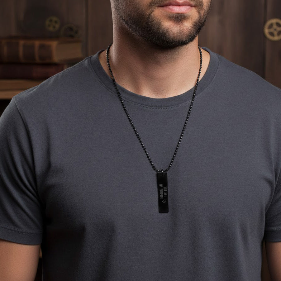 Man wearing a custom engraved dog tag necklace, chain length prominent, tag engraved with a special message on front. Sleek masculine design in stainless steel plane-tag style, ideal for men’s everyday jewelry, father’s day gift, boyfriend gift, best man gift.