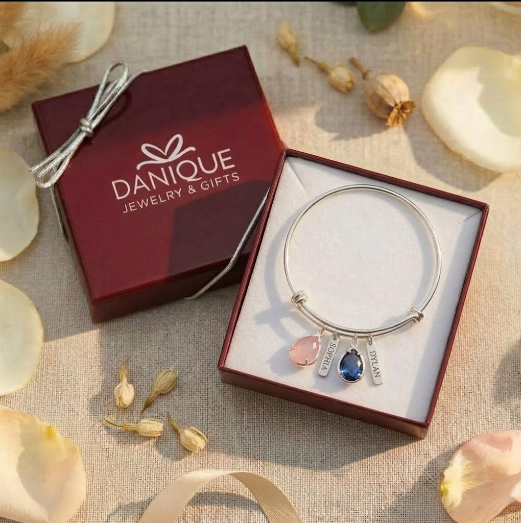 Personalized silver birthstone bangle presented in a burgundy Danique Jewelry gift box with bow.