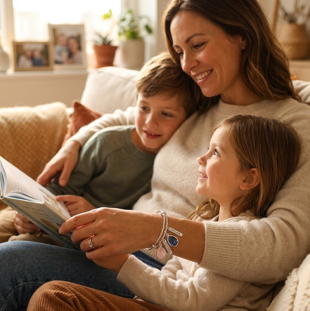 Mother relaxing with two children while wearing a personalized family birthstone bracelet with engraved name charms.