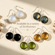 Large round faceted Smoky Quartz drop earrings in yellow gold displayed in warm natural light.
