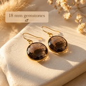 Large round Smoky Quartz earrings with 18 mm faceted brown gemstones in yellow gold settings.
