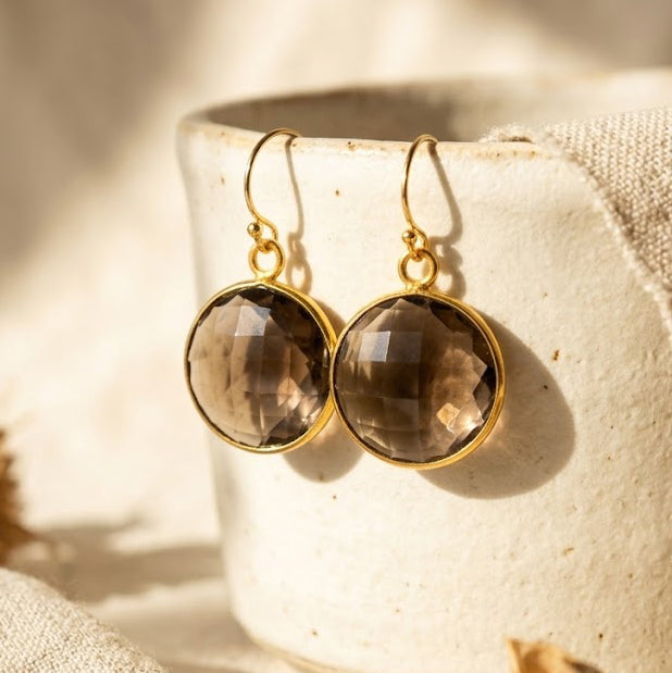 Large round Smoky Quartz drop earrings in yellow gold with faceted translucent brown gemstones.
