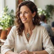 Woman wearing Natural Sage sculptural Ribbon Cascade necklace and earrings with cream blouse