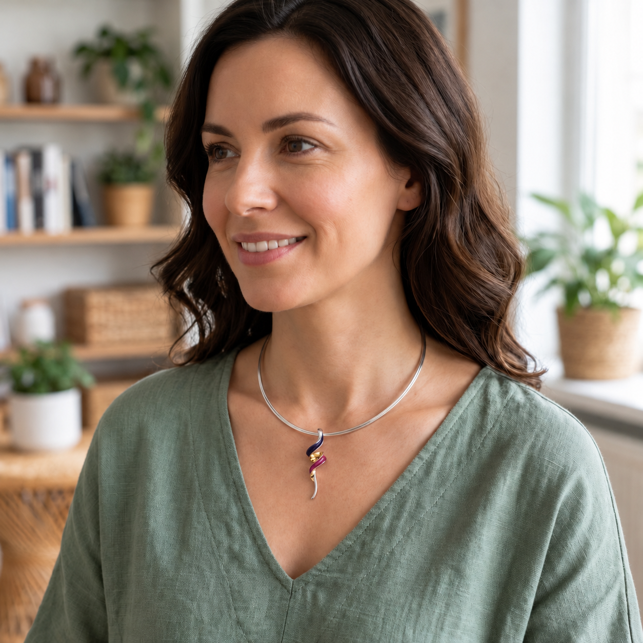 Woman wearing colorful boho spiral statement necklace with sage green blouse