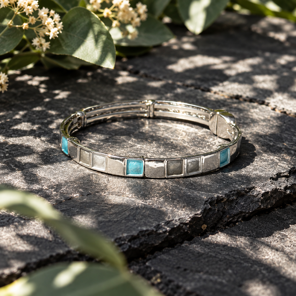 
Silver Mosaic Squares bracelet with teal accent displayed in botanical shadows