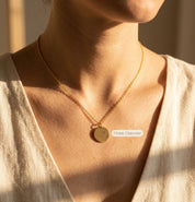 Woman wearing engraved state necklace with heart location marker
