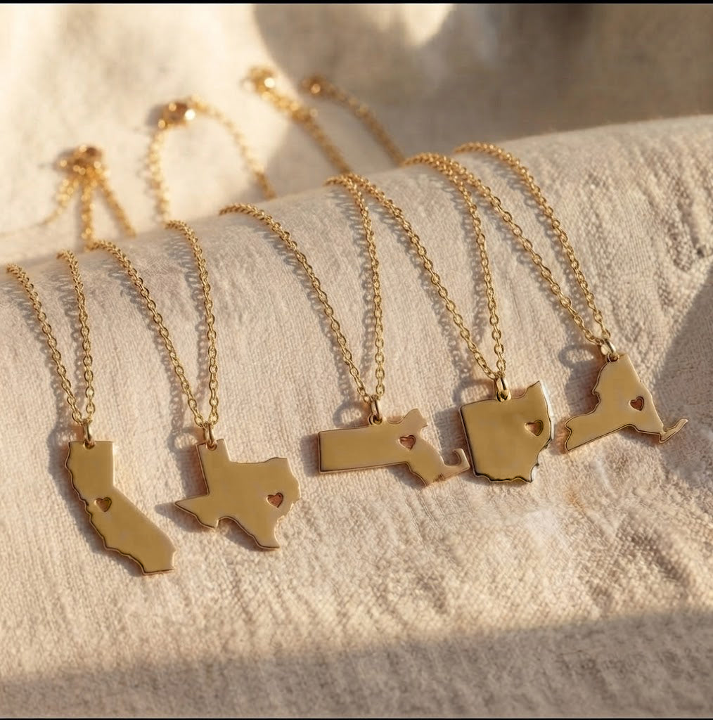Personalized state and county map necklaces displayed on delicate gold chains