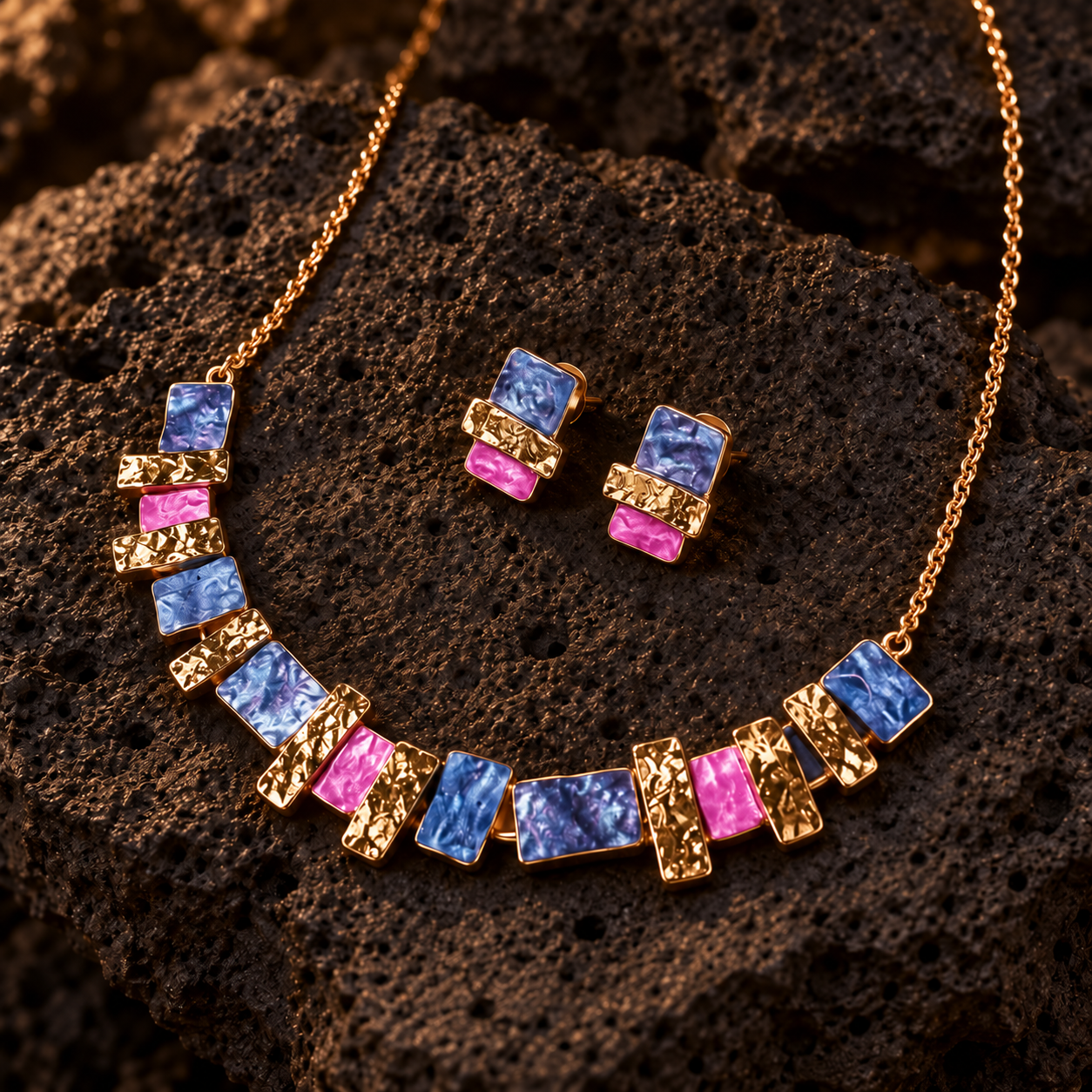 Colorful stacked squares necklace and matching studs in blue pink and gold on dark textured stone
