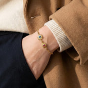 Woman wearing a custom sunburst birthstone bracelet on her wrist, showing faceted bezel-set gemstones in different sizes for mom and child. Personalized mother and children bracelet designed for everyday wear and sentimental gifting.