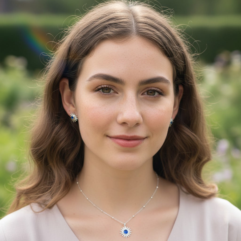 Woman wearing a personalized sunburst birthstone necklace with peridot August gemstone. A celestial pendant necklace that shines as a birthday gift or self-love jewelry.