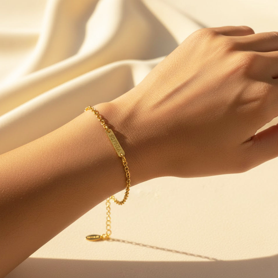 dainty personalized tiny bar bracelet worn on a woman’s wrist, featuring engraved gold vermeil bar on a delicate chain, minimalist and elegant for everyday wear, customizable with names, initials or meaningful dates, available with adjustable or fixed length options, perfect personalized jewelry gift for birthdays, bridesmaids, moms, sisters or girlfriends, crafted in sterling silver or gold vermeil with multiple engraving font choices