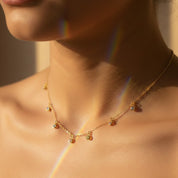 Close-up of custom birthstone necklace with multiple tiny bezel gemstones in sterling silver and gold — personalized family keepsake necklace gift for mom and grandma