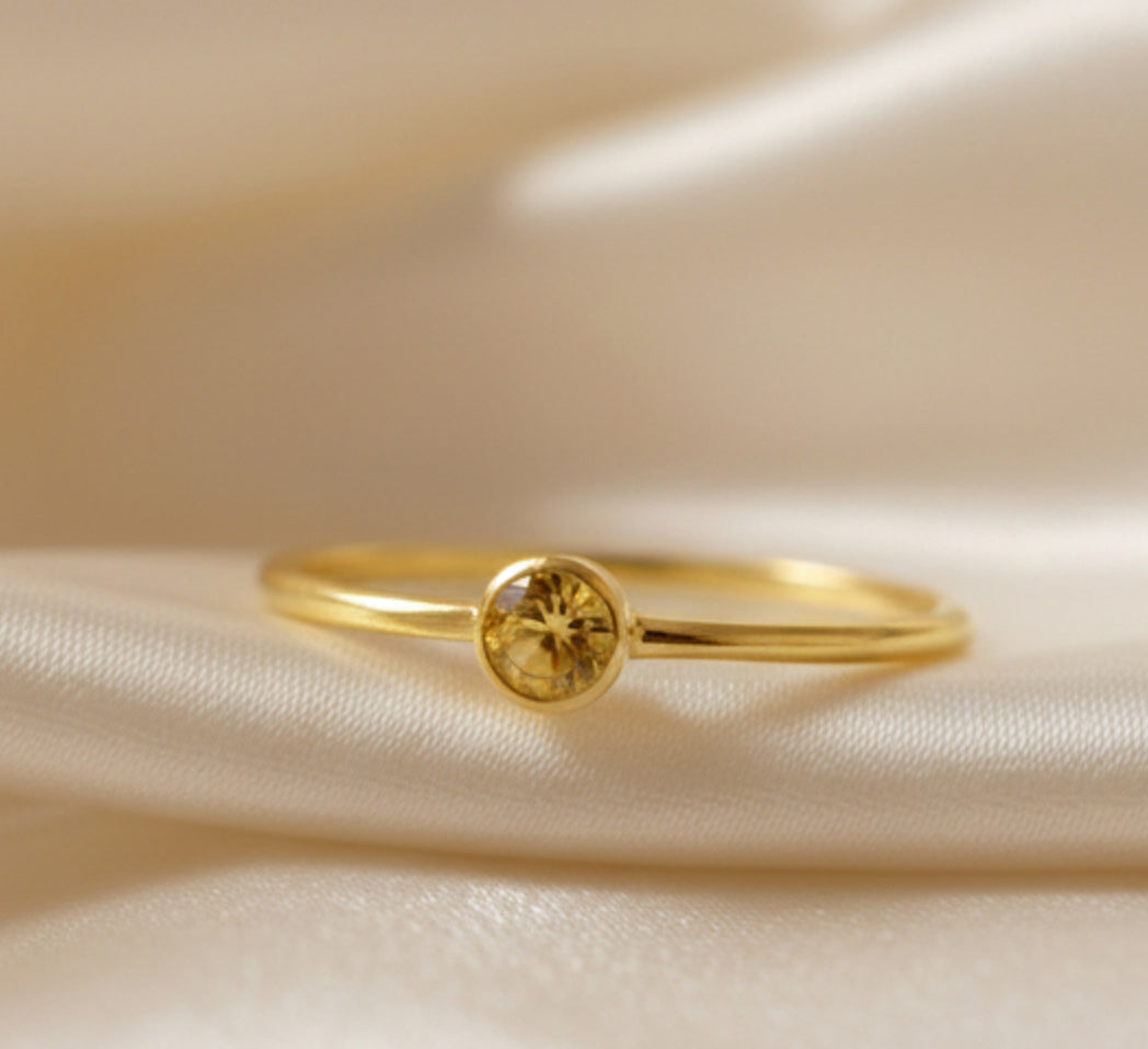 Minimal gold citrine ring on white background, petite bezel-set November birthstone, handcrafted stackable jewelry.