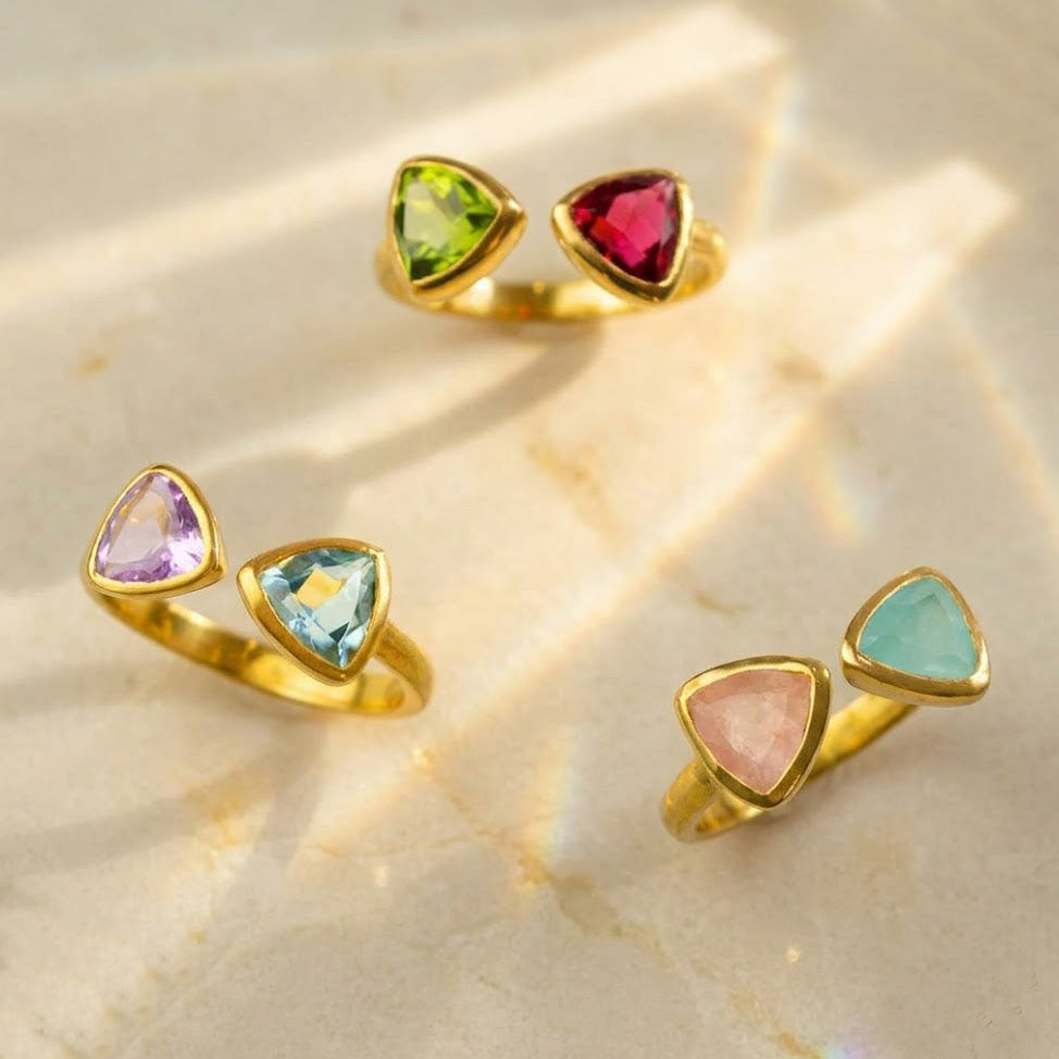 Custom two birthstone triangle rings in yellow gold with colorful gemstones
