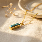 Personalized turquoise bar necklace with engraved name on a gold chain, styled as a December birthstone gift.