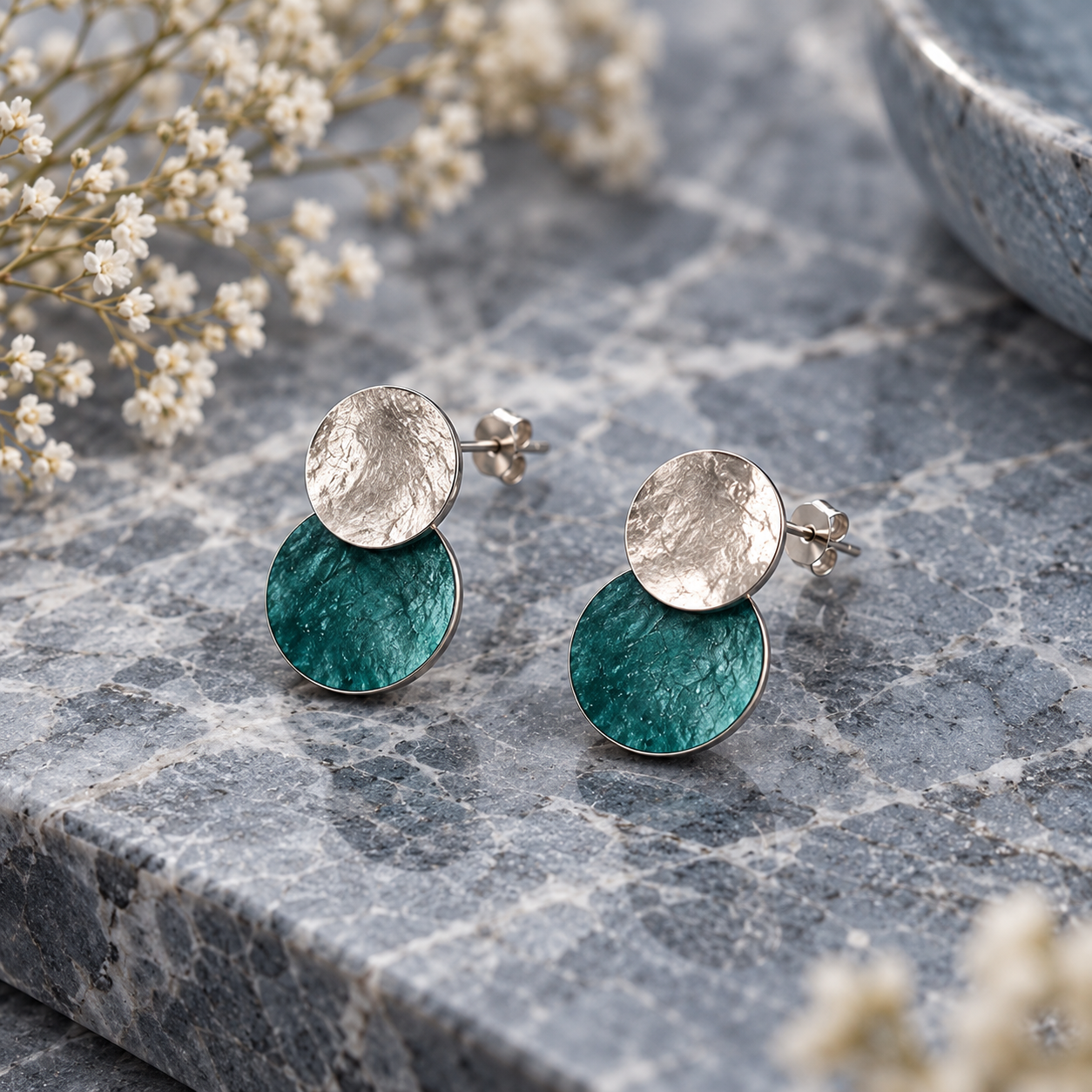 Turquoise and Silver hammered double disc stud earrings displayed on gray stone background
