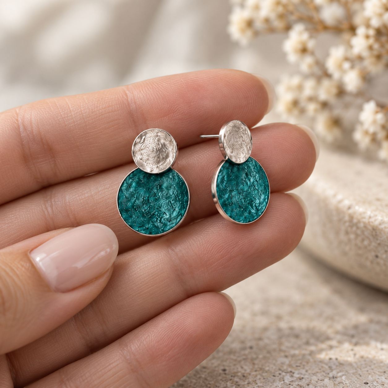 Hand holding Turquoise and Silver double disc stud earrings showing layered round design

