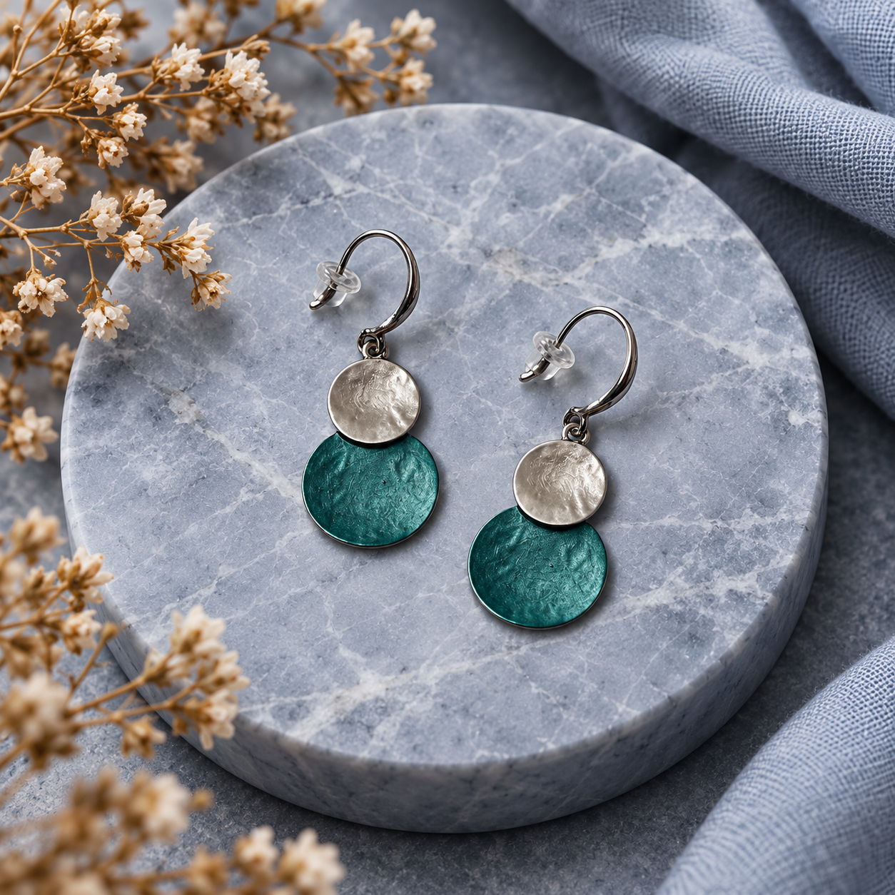 Teal Green and Silver hammered double disc earrings displayed on gray stone
