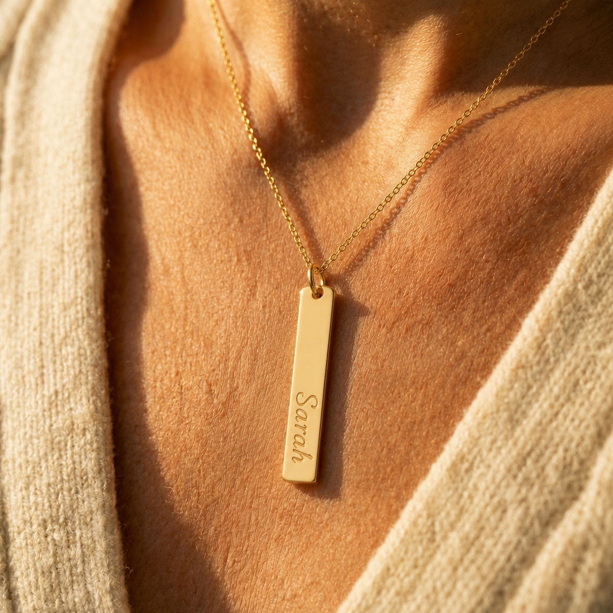 Model wearing a personalized yellow gold-filled vertical bar necklace in warm natural light