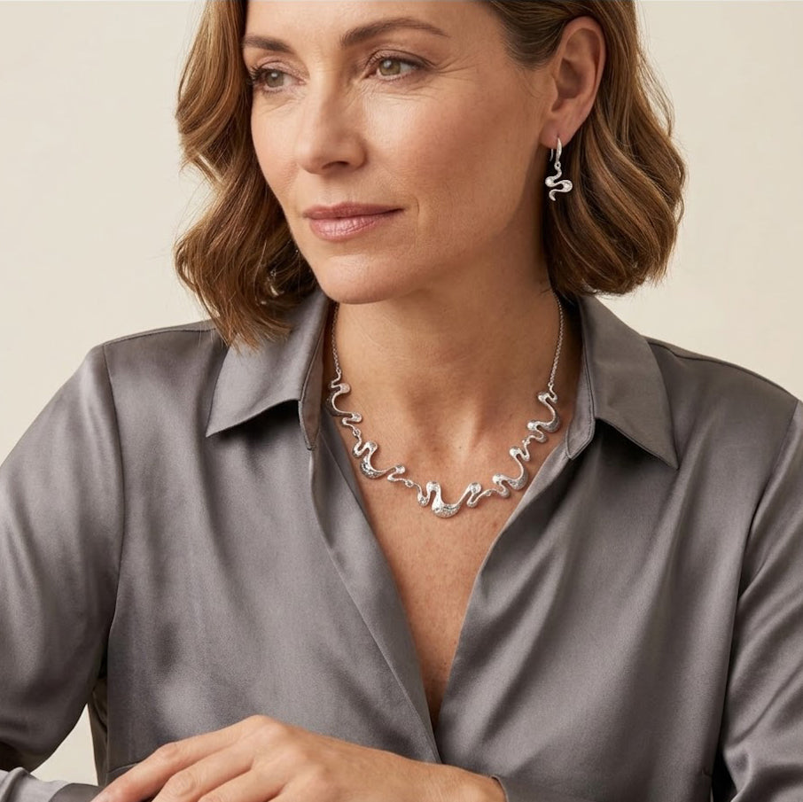 Model wearing silver wave necklace and earrings with gray blouse for modern boho styling