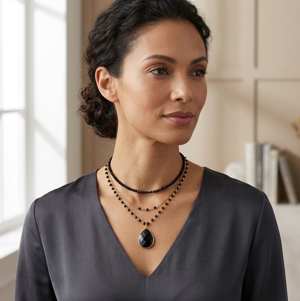 Woman wearing black teardrop gemstone necklace with wire wrapped chain
