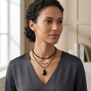Woman wearing black teardrop gemstone necklace with wire wrapped chain
