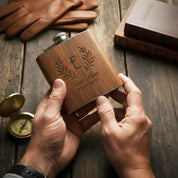 Hands holding a personalized engraved wooden flask, showcasing custom engraving detail. Custom whiskey flask made for gifting.