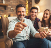 Smiling dad holding personalized wrench keychain engraved “DAD,” custom stainless steel tool key ring, unique Father’s Day or Christmas gift from kids, funny handyman present for dad or grandpa, family celebrating and exchanging gifts in cozy living room.