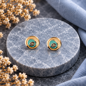 Turquoise and gold boho spiral stud earrings on dark textured background

