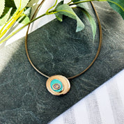 A rose gold and teal necklace on a steel wire cable chain with matching earrings against a black granite background. Teal and rose gold abstract statement necklace, abstract rose flower necklace, bohemian flower jewelry, boho natural earthy jewelry