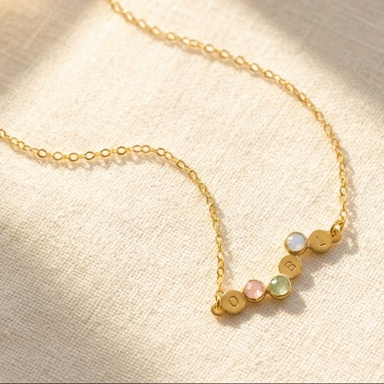 Personalized birthstone and initial necklace with four petite family gemstones in yellow gold
