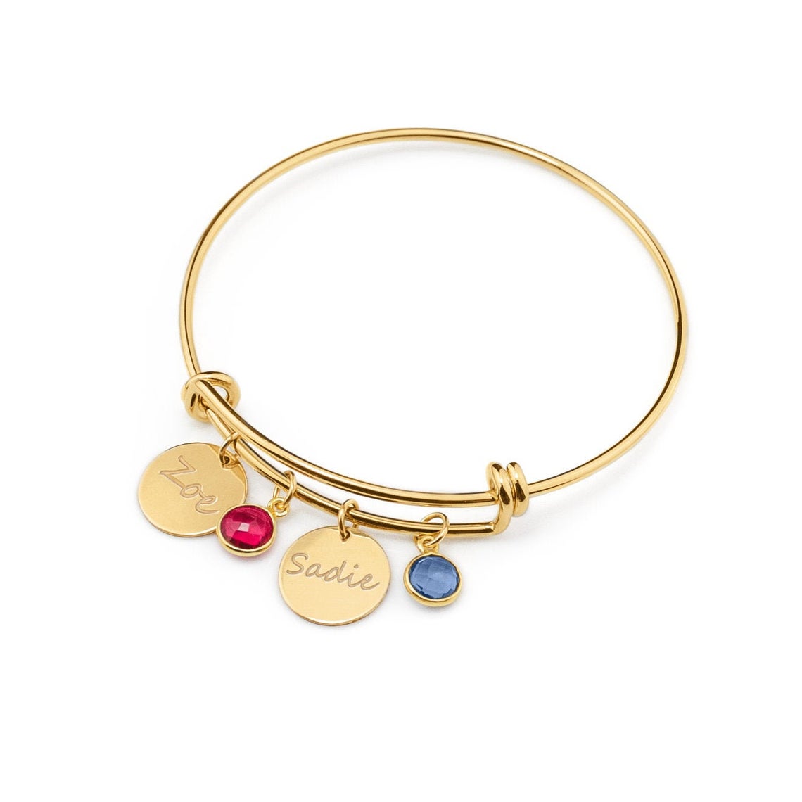 Gold bangle bracelet with engraved disks in handwriting script and garnet and kyanite birthstones. 