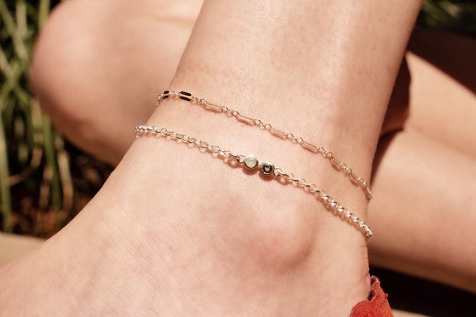 Model layering multiple silver anklets. One silver anklet with 3mm moonstone and purple amethyst. 